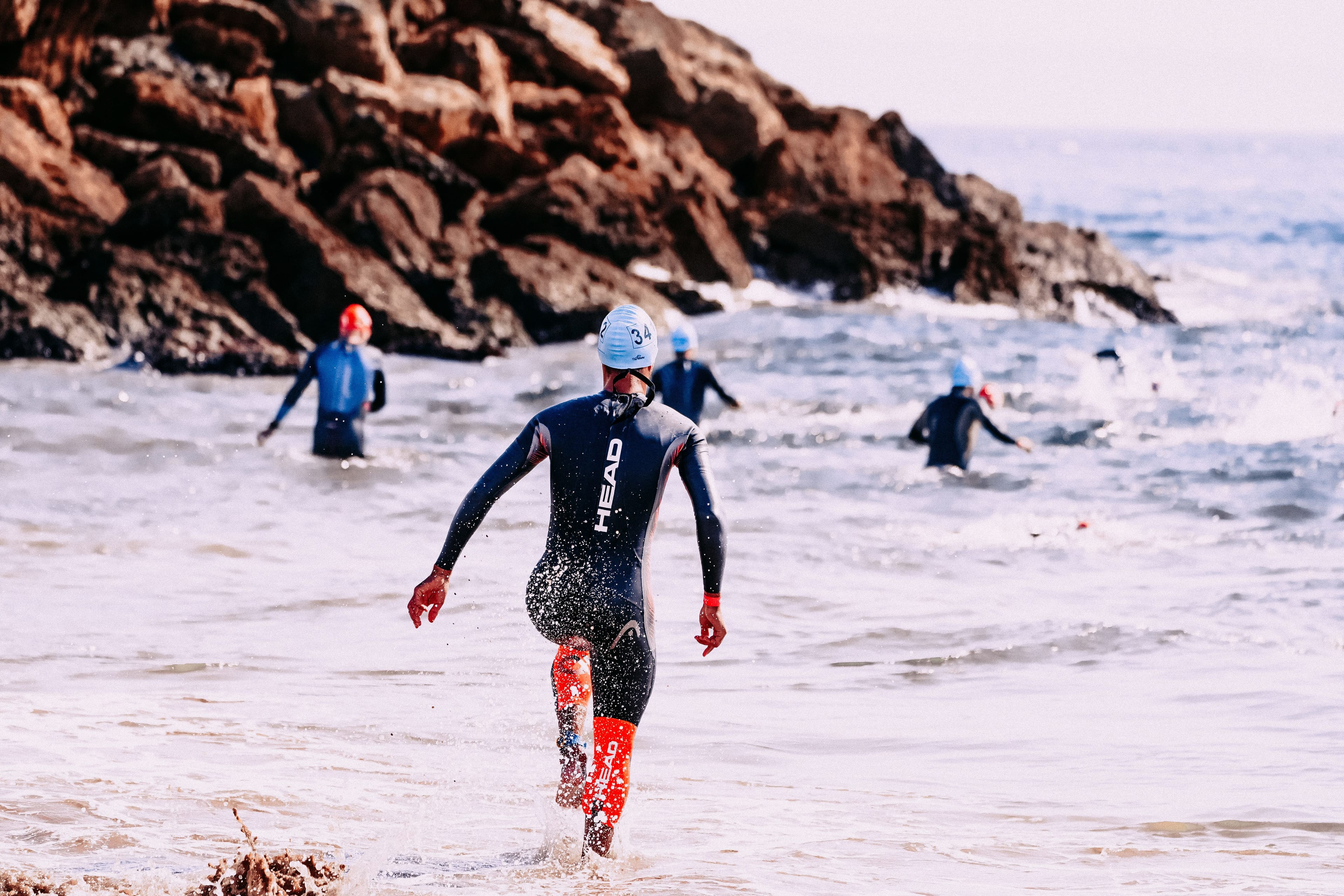 Triathletes running into the sea at a race start